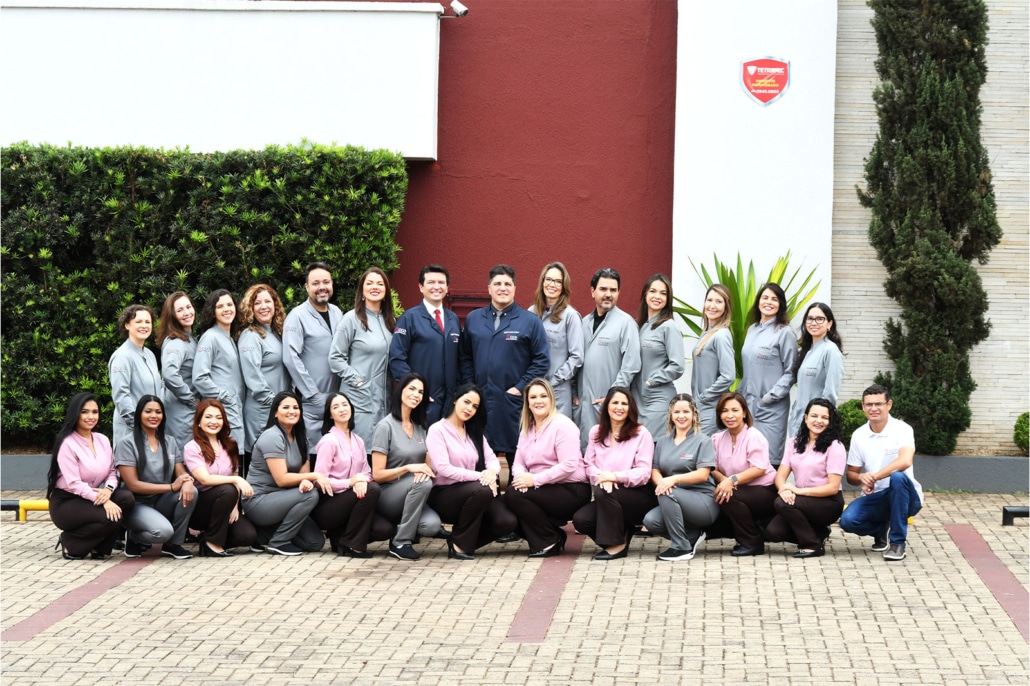 Equipe do centro de cirurgia oral em frente à fachada da clínica